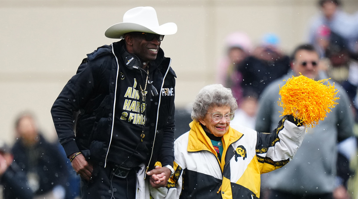 Deion Sanders walks onto Folsom Field with 98-year-old Colorado superfan Peggy Coppom for the 2023 spring football game.