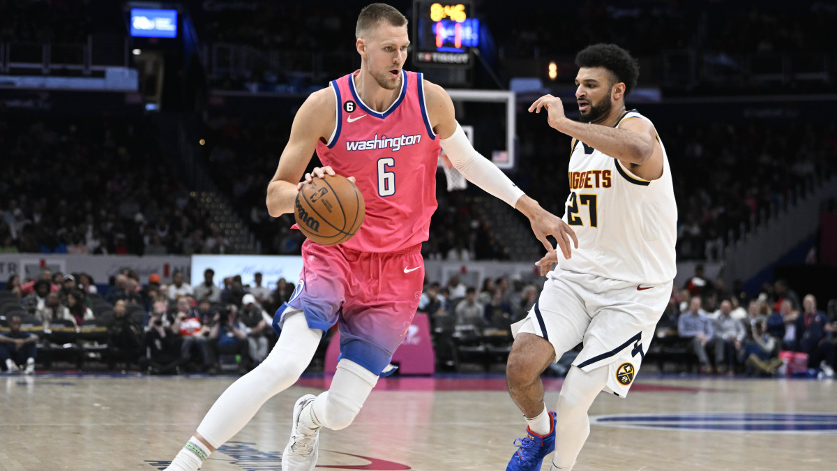 Center Kristaps Porzingis dribbles past Denver Nuggets guard Jamal Murray.