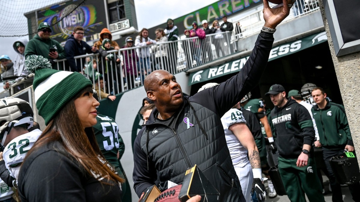Brenda Tracy, left, stands with Mel Tucker at the 2022 Michigan State spring game.