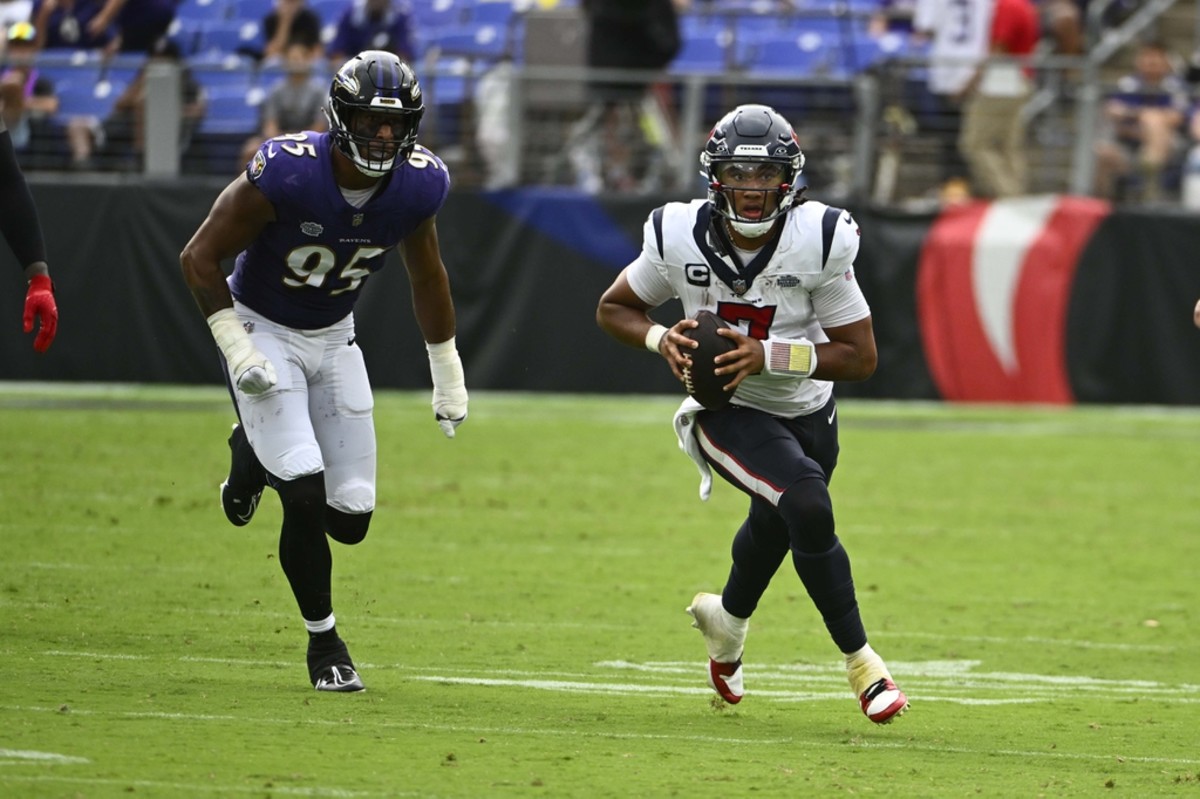 Houston Texans quarterback C.J. Stroud (7) carries the ball as Baltimore Ravens linebacker Tavius Robinson (95) chases during the second half at M&T Bank Stadium.