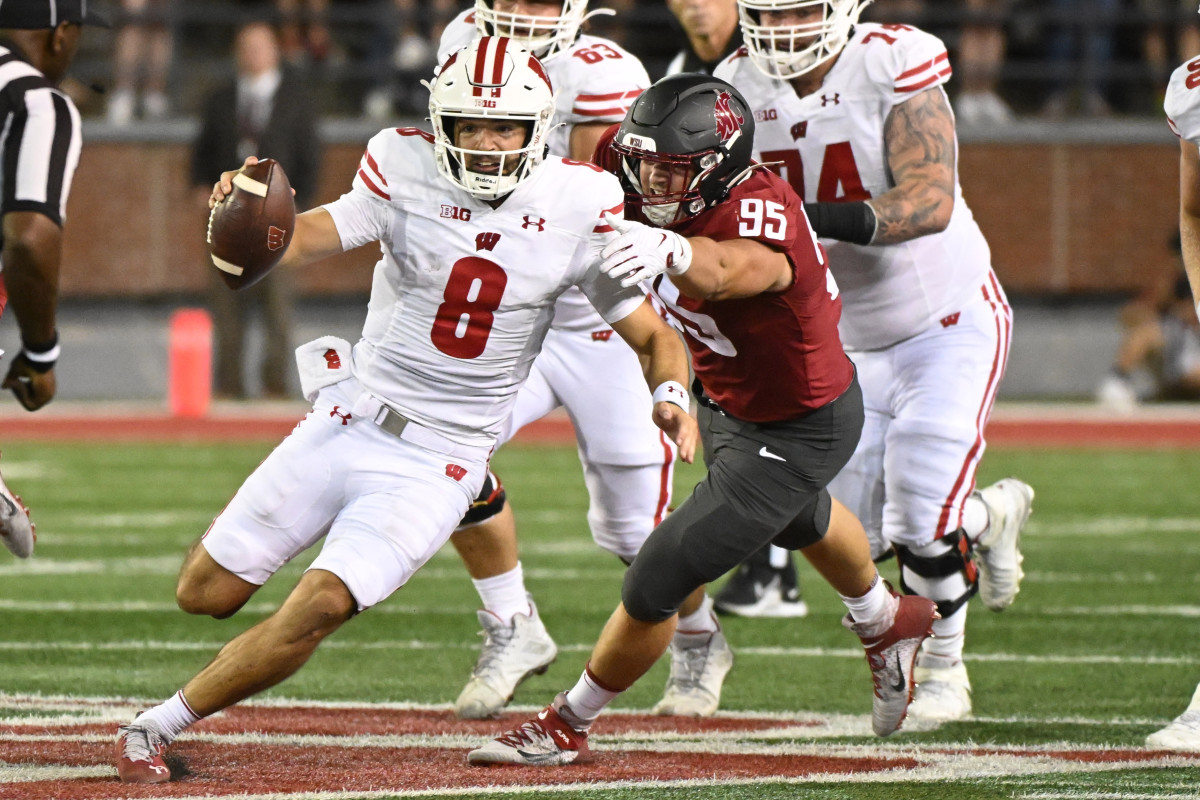 Sep 9, 2023; Pullman, Washington, USA; Wisconsin Badgers quarterback Tanner Mordecai (8) is tackled from behind by Washington State Cougars defensive end Andrew Edson (95) in the second half at Gesa Field at Martin Stadium. Washington State won 31-22. Mandatory Credit: James Snook-USA TODAY Sports