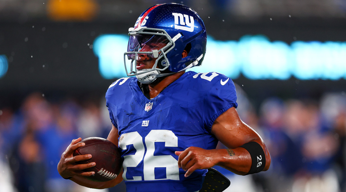Giants running back Saquon Barkley (26) runs with the ball during warmups before a game against the Cowboys.