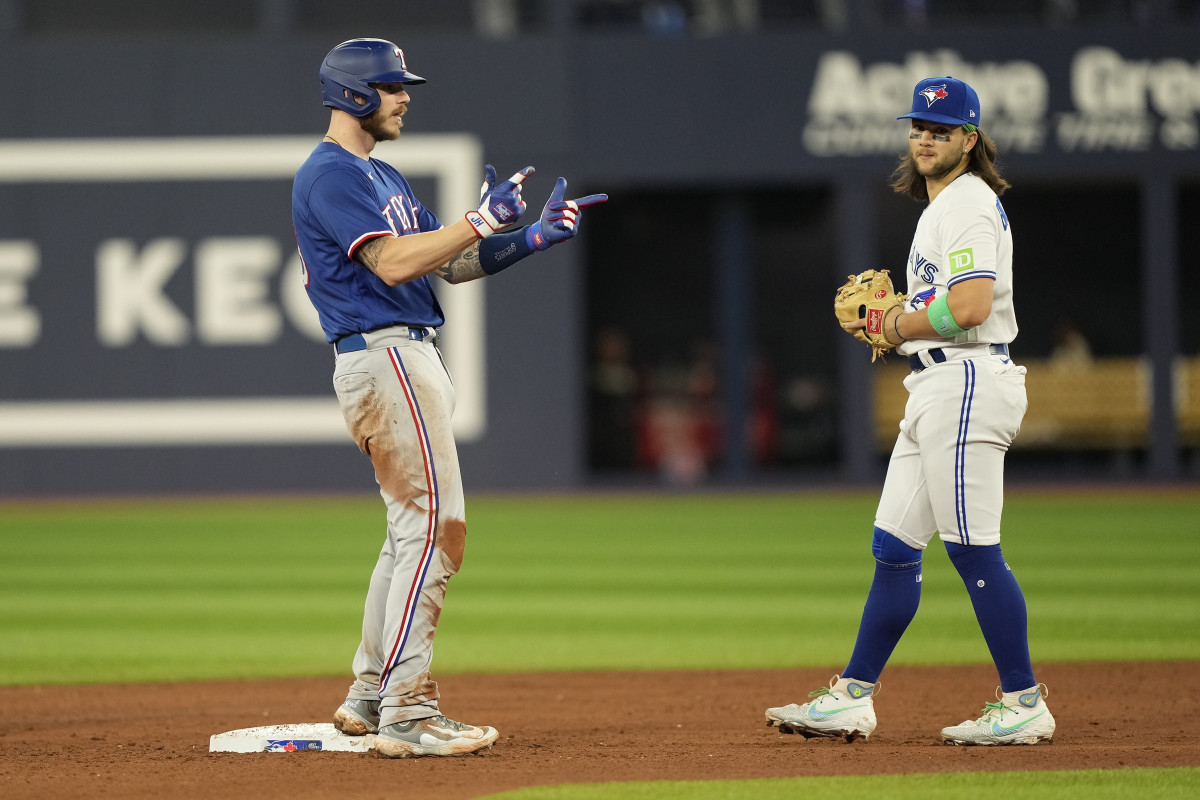 Texas Rangers designated hitter Jonah Heim celebrates his RBI double as Toronto Blue Jays shortstop Bo Bichette looks on in the sixth inning at Rogers Centre Monday. Heim had a grand slam in the seventh to pace the Rangers' 10-3 win.