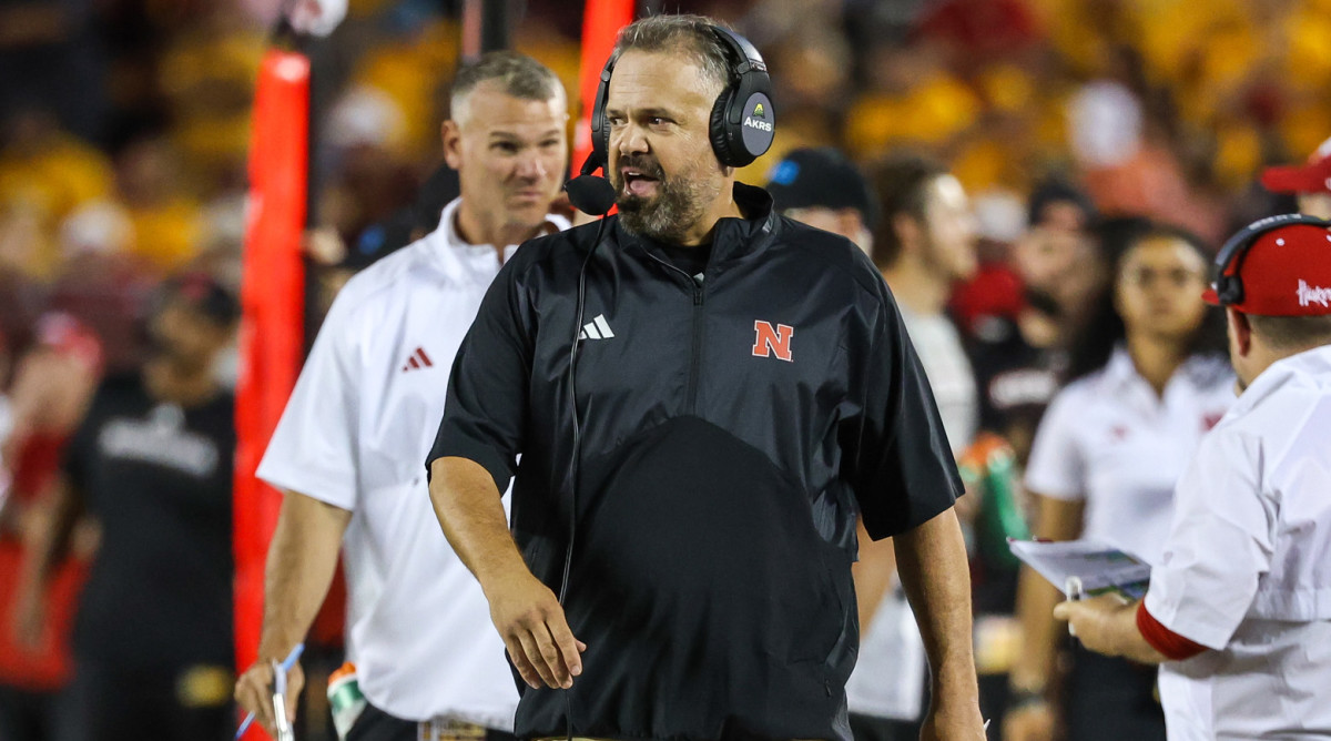 Nebraska head coach Matt Rhule talks into his headset while pacing the sidelines against Minnesota.