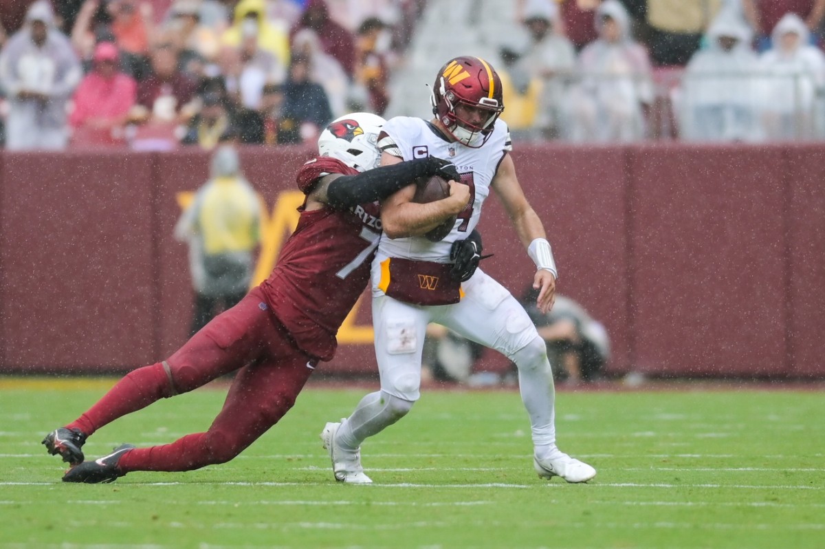 Sep 10, 2023; Landover, Maryland, USA; Washington Commanders quarterback Sam Howell is tackled from behind by Arizona Cardinals linebacker Kyzir White (7) during the second half at FedExField.