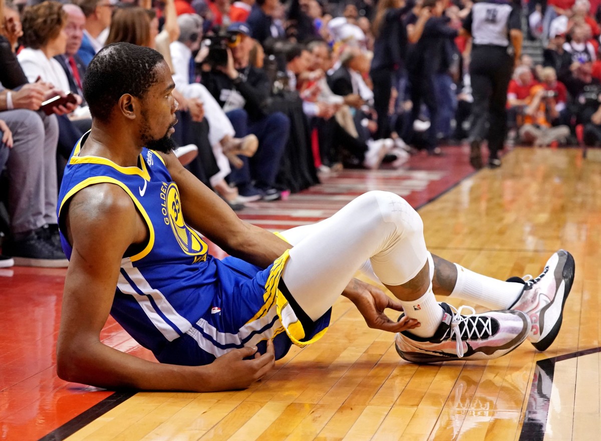 Warriors forward Kevin Durant grabs the back of his ankle after tearing his Achilles tendon in Game 5 of the NBA Finals against the Raptors in 2019.