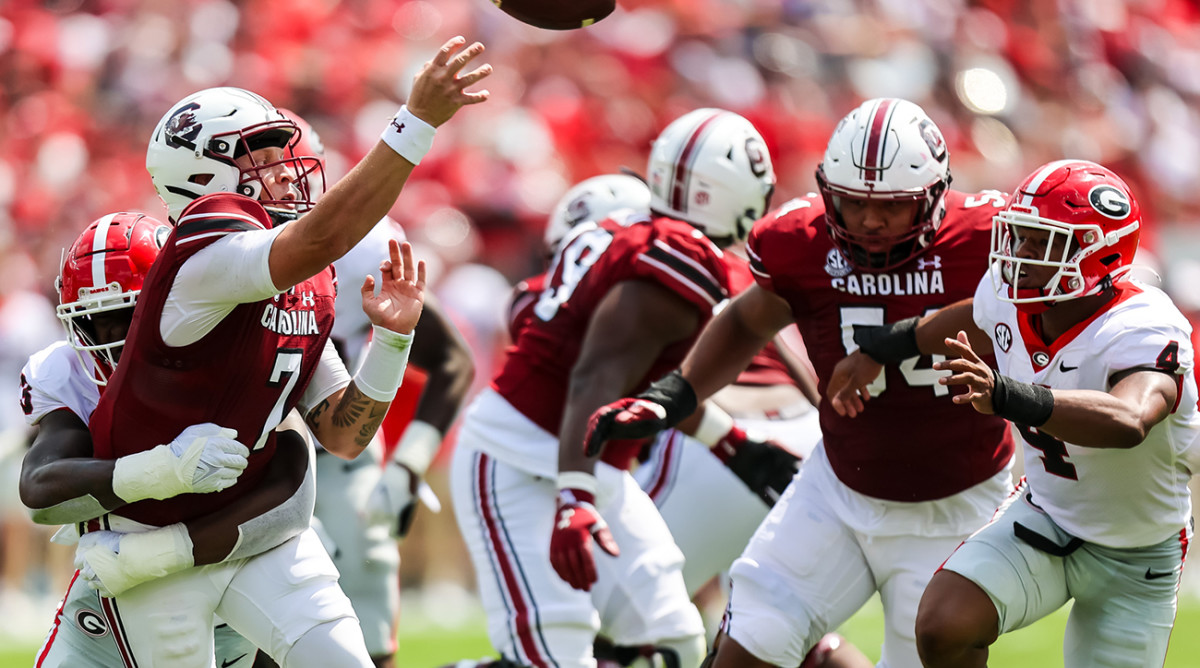 Georgia defender tackles South Carolina QB Spencer Rattler as he throws a pass.
