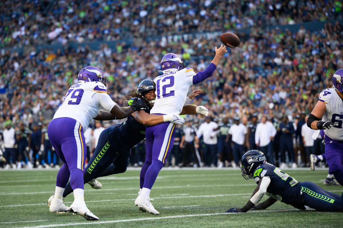 Aug 10, 2023; Seattle, Washington, USA; Seattle Seahawks defensive end Mike Morris (94) hits Minnesota Vikings quarterback Nick Mullens (12) while passing the ball during the first half at Lumen Field. Mandatory Credit: Steven Bisig-USA TODAY Sports