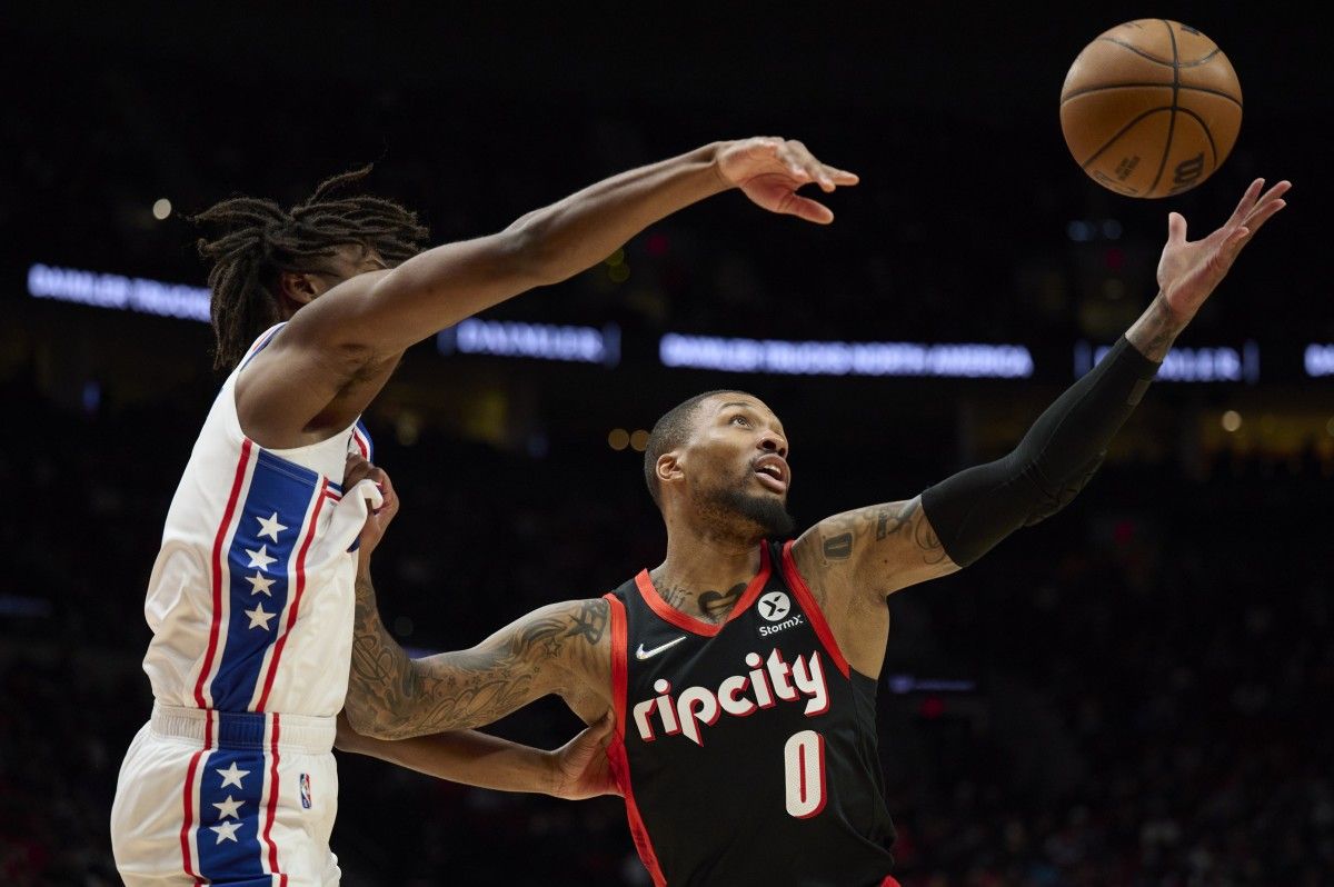 76ers guard Tyrese Maxey fights for a ball against Blazers guard Damian Lillard.