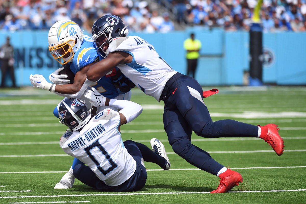 Los Angeles Chargers running back Elijah Dotson (42) is tackled by Tennessee Titans cornerback Sean Murphy-Bunting (0) and linebacker Azeez Al-Shaair (2) during the first half at Nissan Stadium.