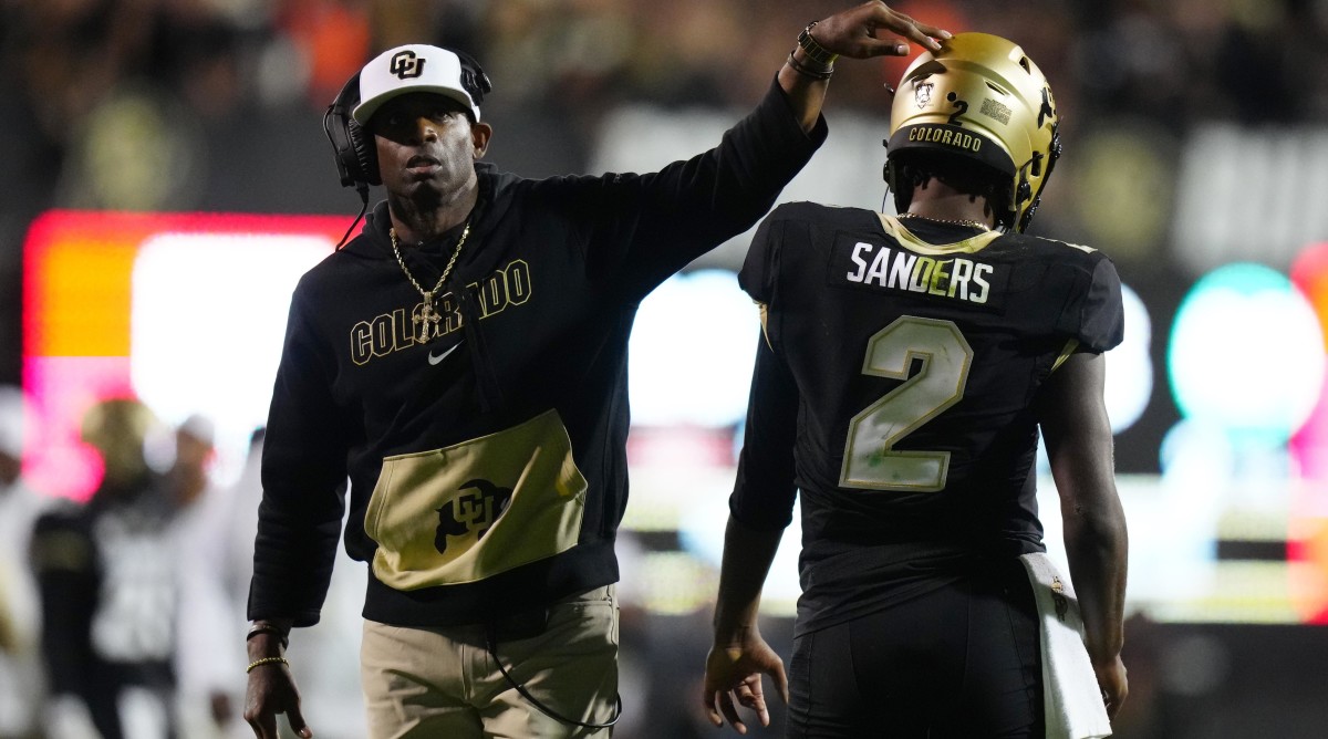 Deion Sanders with his son on the sidelines.