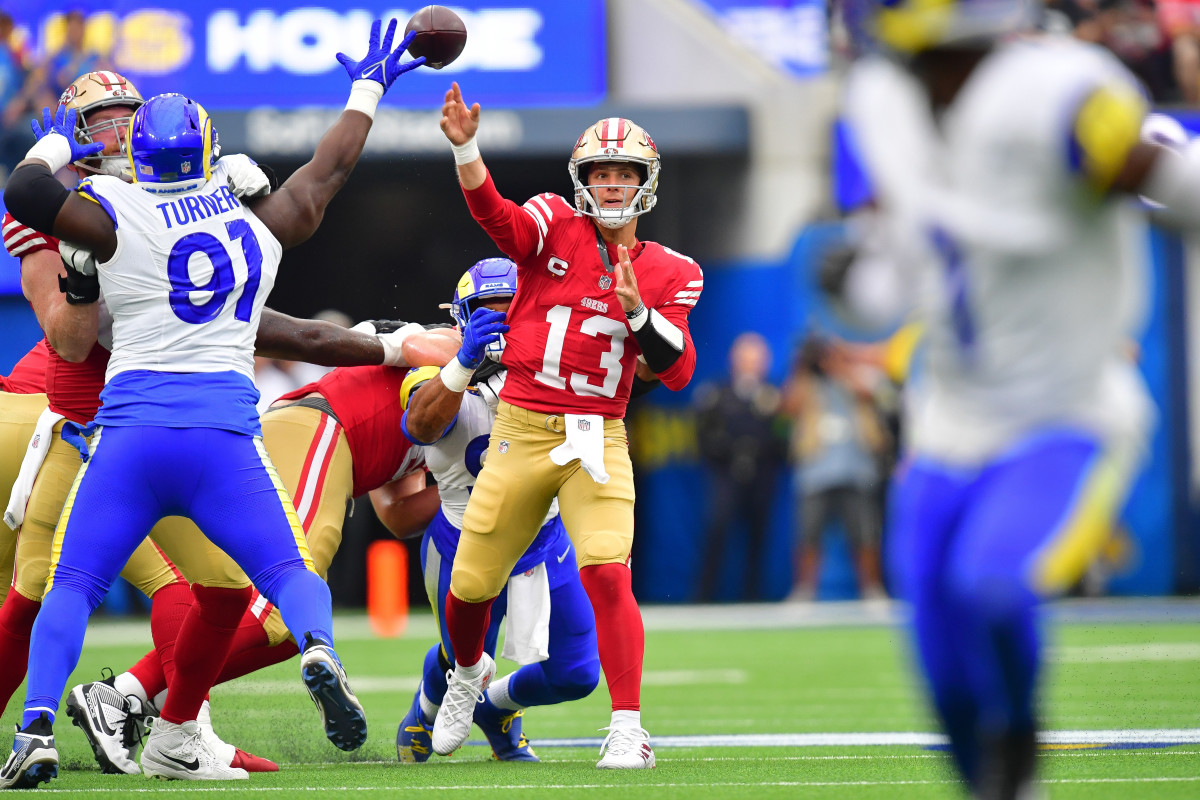 Sep 17, 2023; Inglewood, California, USA; San Francisco 49ers quarterback Brock Purdy (13) throws under pressure from Los Angeles Rams defensive tackle Kobie Turner (91) during the first half at SoFi Stadium. Mandatory Credit: Gary A. Vasquez-USA TODAY Sports