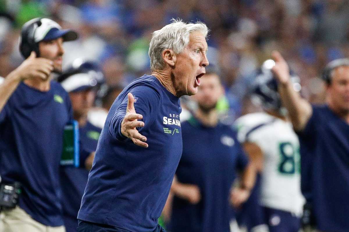 Pete Carroll throws his arms out to the side as he yells