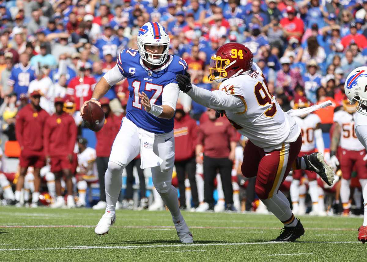 Buffalo Bills quarterback Josh Allen breaks a tackle against Washington defensive tackle Daron Payne.