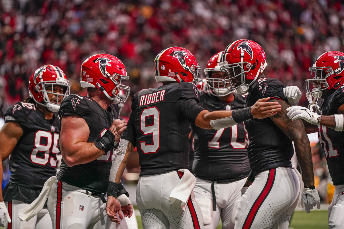 Atlanta Falcons quarterback Desmond Ridder celebrating with Kyle Pitts and the offense against the Green Bay Packers.