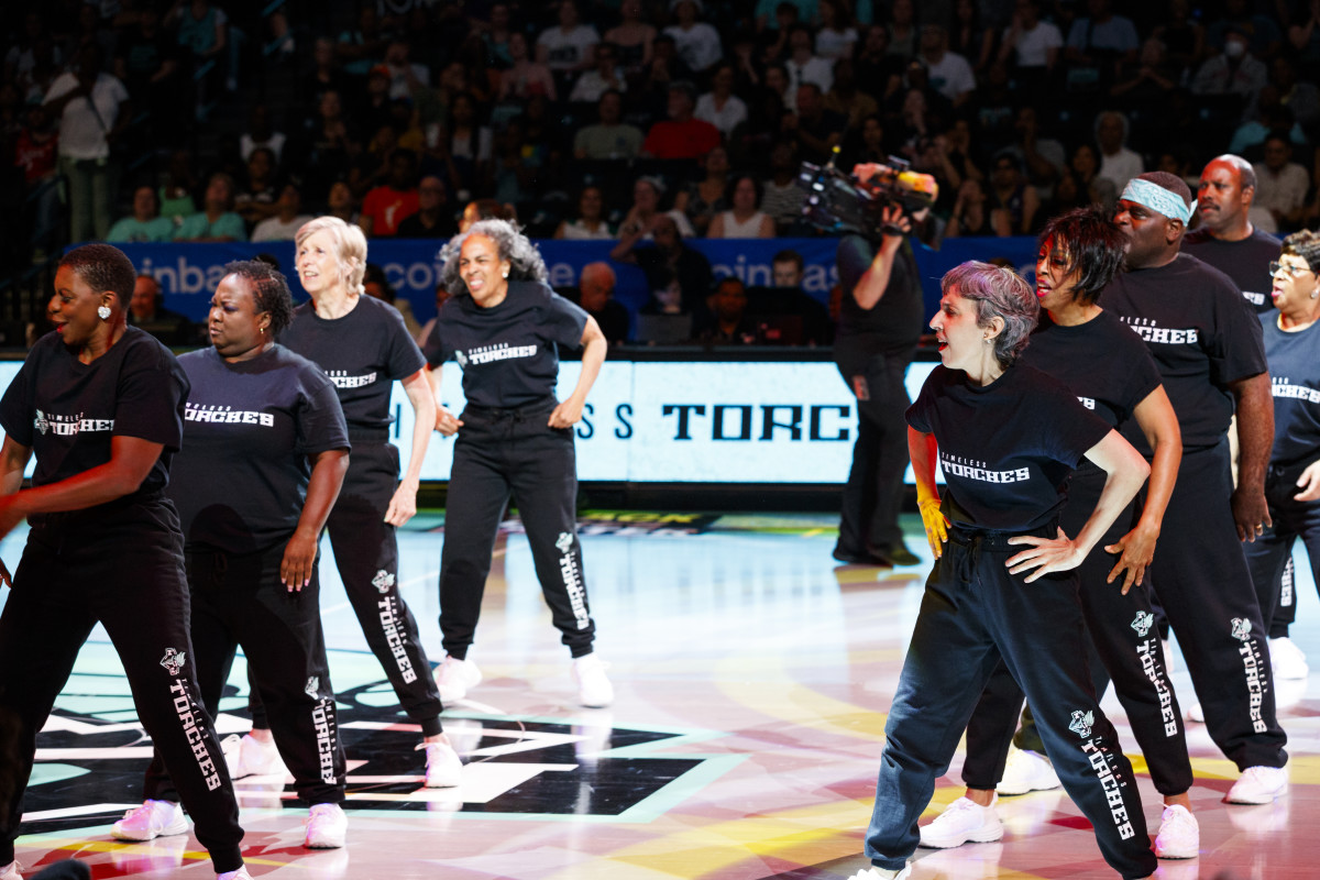 Members of the Timeless Torches perform on the court during a New York Liberty game.