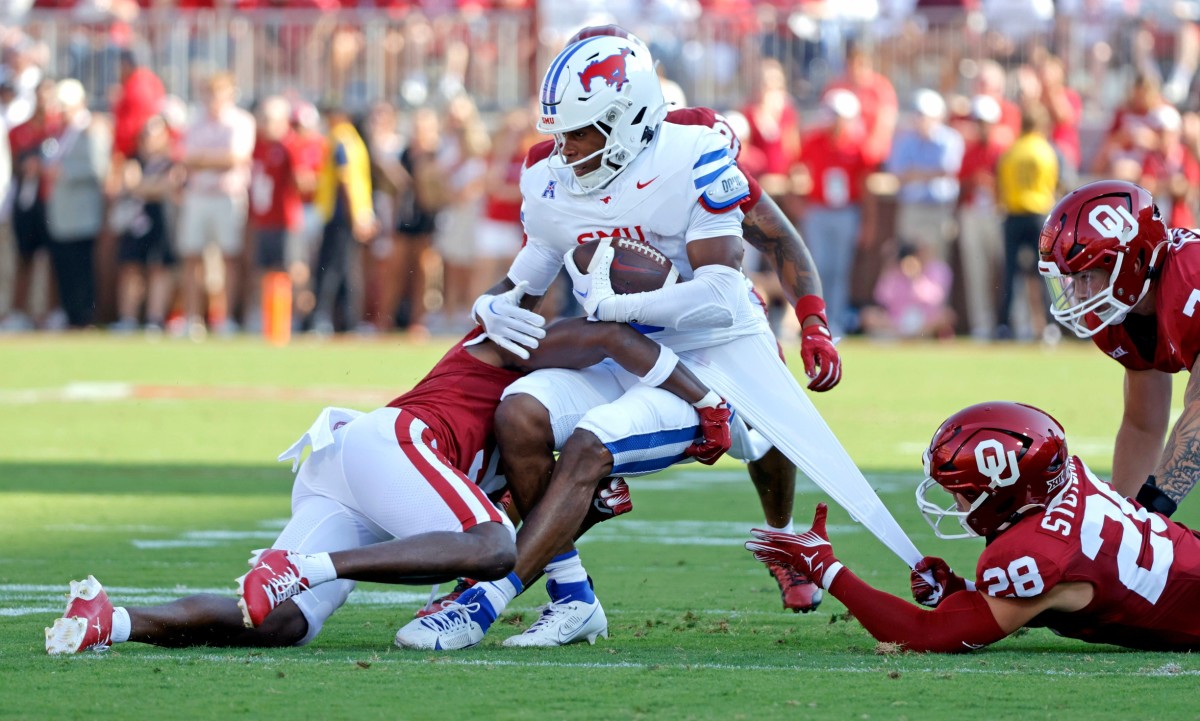 Oklahoma's Danny Stutsman (28) and Gentry Williams (9) tackle SMU's Keldric Luster (6) in the first half of the college football game between the University of Oklahoma Sooners and the Southern Methodist University Mustangs at the Gaylord Family Oklahoma Memorial Stadium in Norman, Okla., Saturday, Sept. 9, 2023.