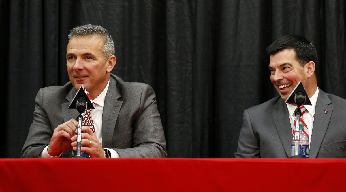 Former Ohio State coach Urban Meyer and current coach Ryan Day speak at a press conference.