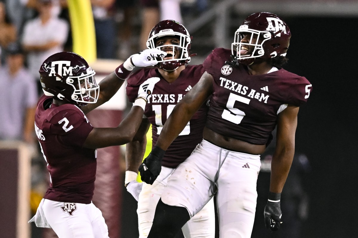 Jacoby Mathews (2) and Fadil Diggs (10) celebrate with Shemar Turner (5) after a tackle for loss.