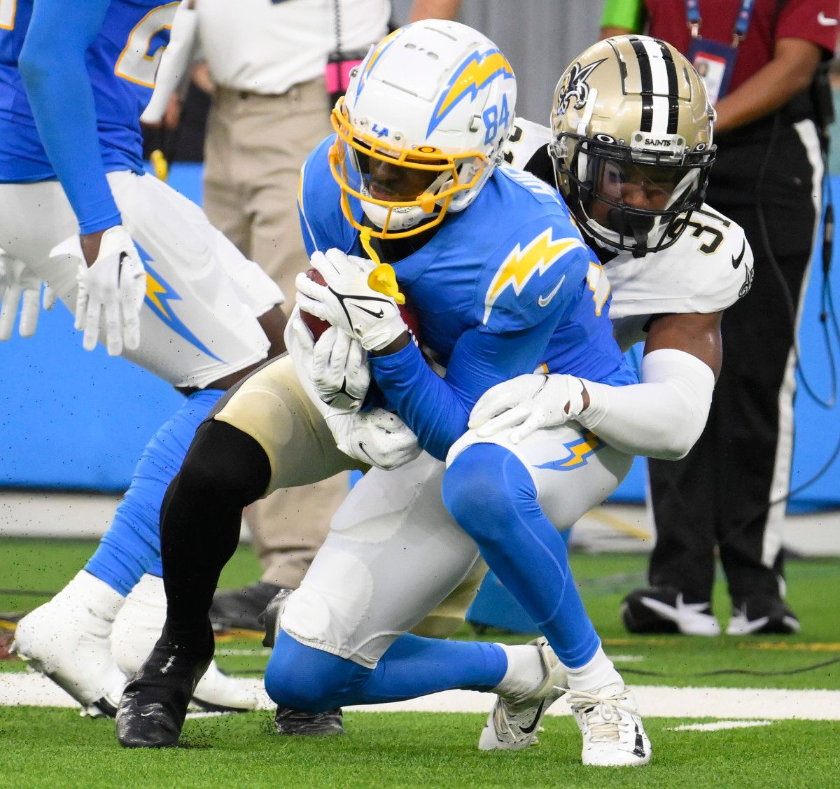 New Orleans Saints safety Jordan Howden makes a tackle on Los Angeles Chargers wideout John Hightower.