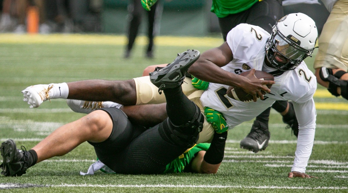 Colorado QB Shedeur Sanders is tackled by an Oregon player.
