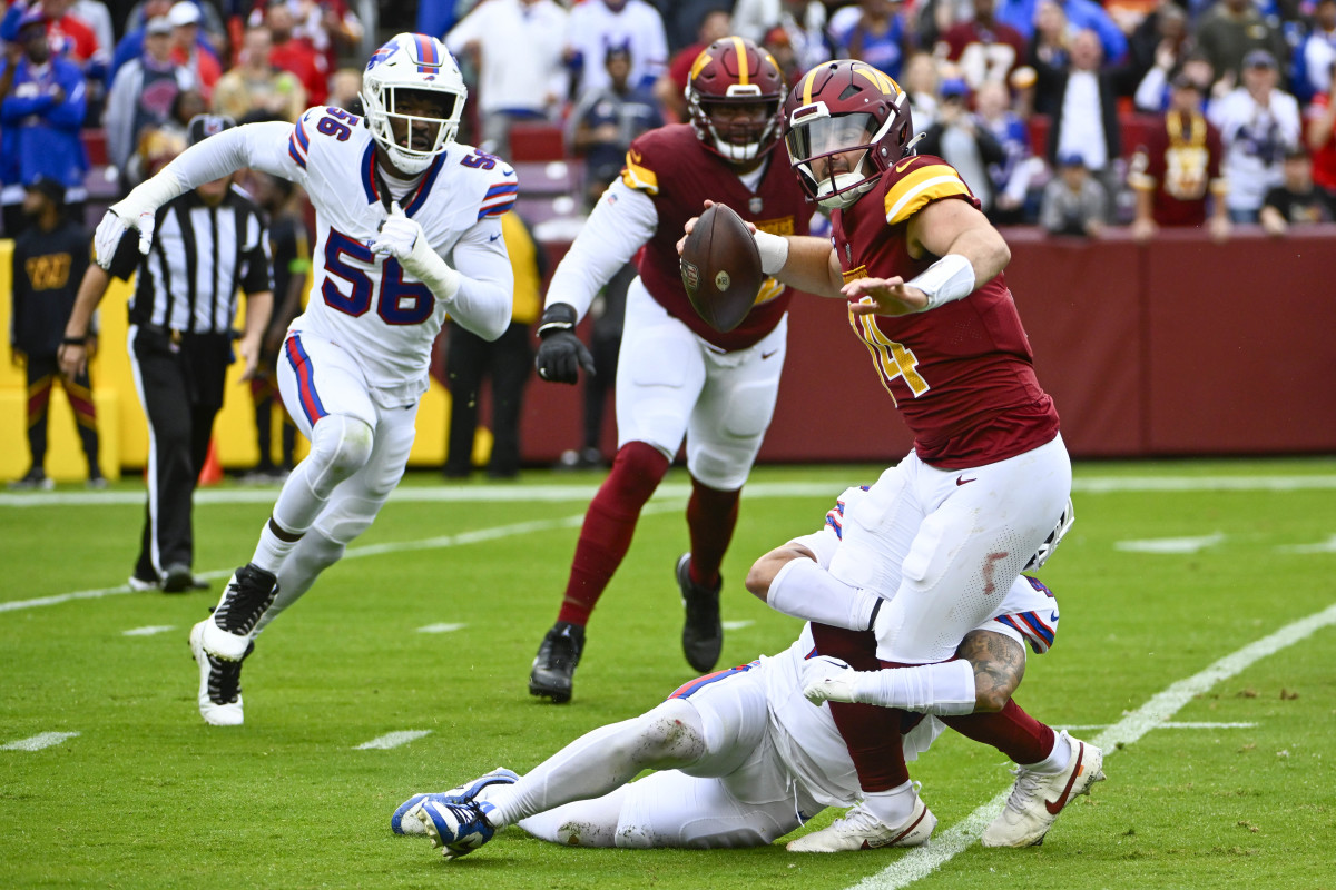 Commanders quarterback Sam Howell attempts to throw a pass while being tackled against the Bills.