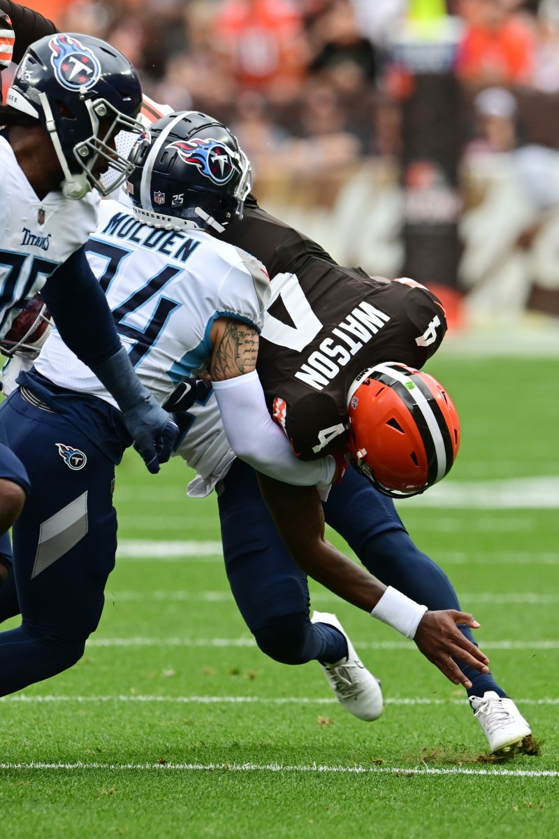 Tennessee Titans cornerback Kristian Fulton (26) tackles Cleveland Browns quarterback Deshaun Watson (4) during the first half at Cleveland Browns Stadium. 