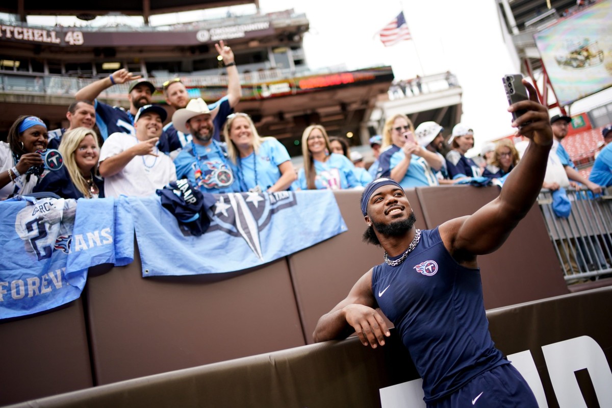 Tennessee Titans linebacker Azeez Al-Shaair (2) takes a selfie with fans as the team gets ready to face the Cleveland Browns in Cleveland, Ohio, Sunday, Sept. 24, 2023.