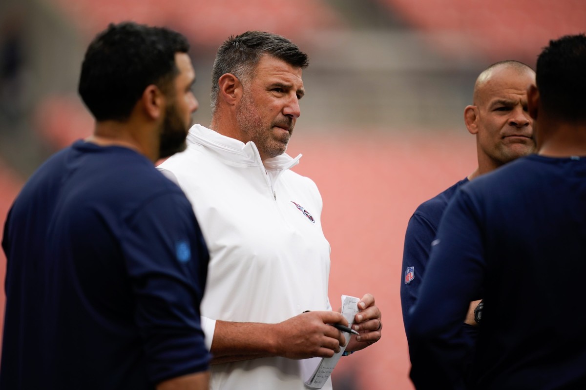 Tennessee Titans head coach Mike Vrabel talks with his staff as the team gets ready to face the Cleveland Browns .