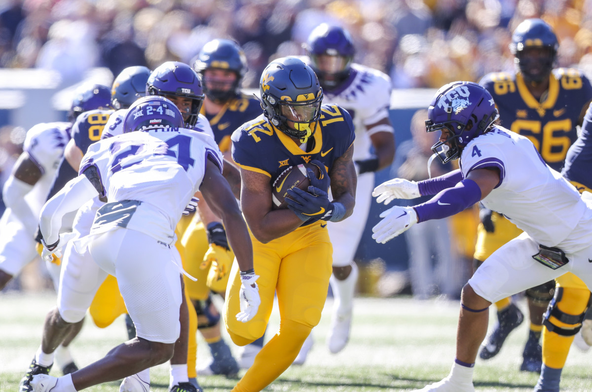 West Virginia Mountaineers running back CJ Donaldson (12) runs the ball during the first quarter against the TCU Horned Frogs at Mountaineer Field at Milan Puskar Stadium.