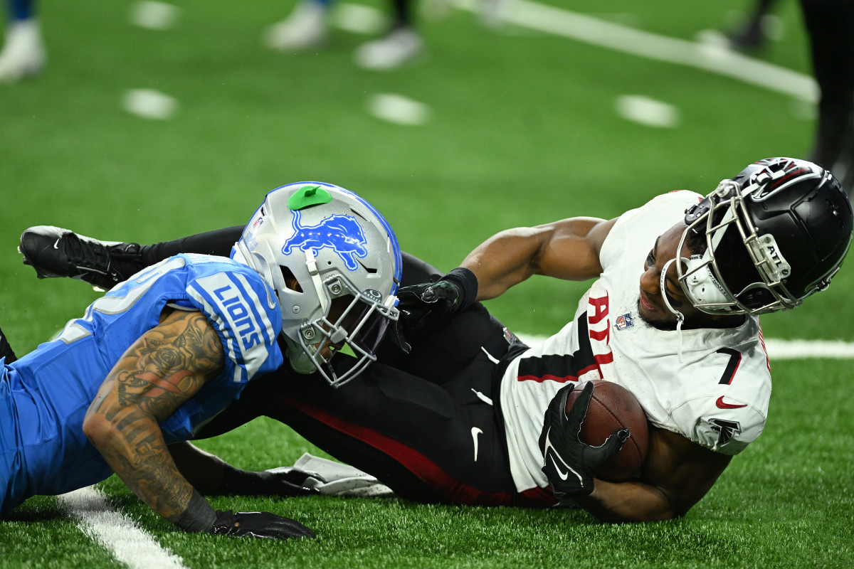 Atlanta Falcons running back Bijan Robinson (7) has his helmet knocked off while being tackled by Detroit Lions safety Brian Branch (32).