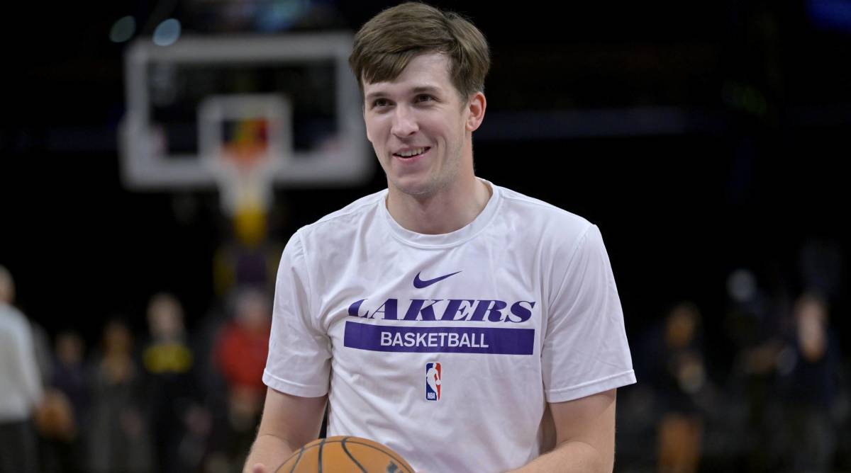 Lakers guard Austin Reaves smiles while warming up before a game.