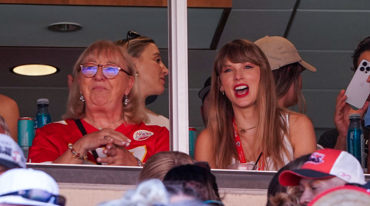 Taylor Swift sits next to Donna Kelce smiling as she watches the Chiefs game from a box