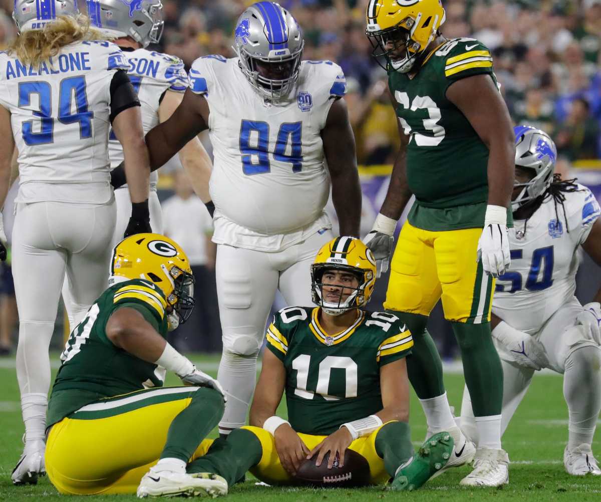 Packers QB Jordan Love sits on the ground after being sacked against the Lions
