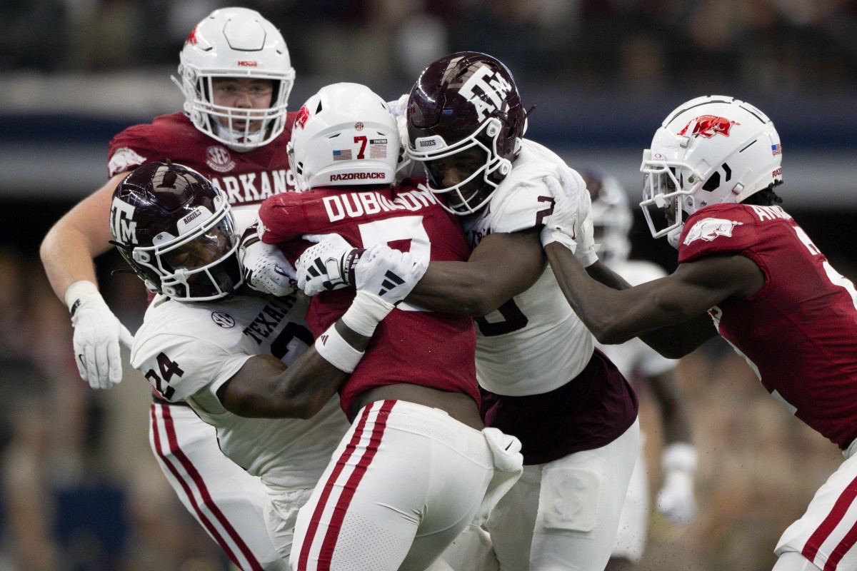 Sep 30, 2023; Arlington, Texas, USA; Arkansas Razorbacks running back Rashod Dubinion (7) is tackled by Texas A&M Aggies linebacker Chris Russell Jr. (24) and defensive back Jacoby Mathews (2) during the first half at AT&T Stadium. Mandatory