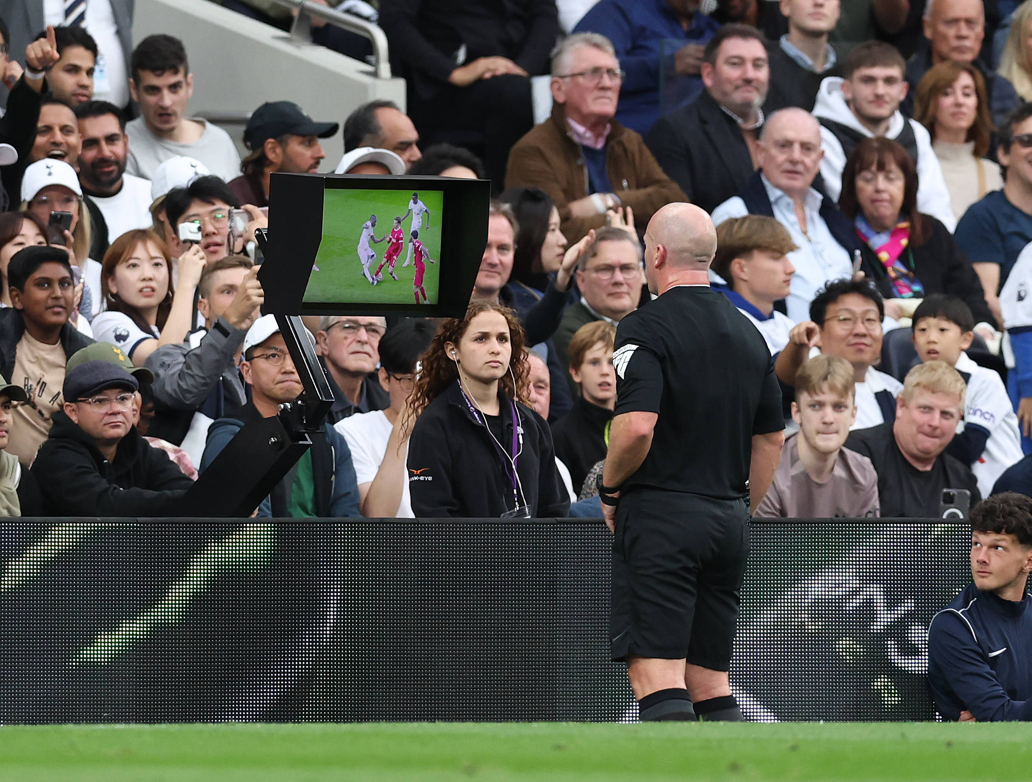 Referee Simon Hooper pictured looking at a pitch-side monitor moments before sending off Curtis Jones during Liverpool's 2-1 defeat at Tottenham in September 2023