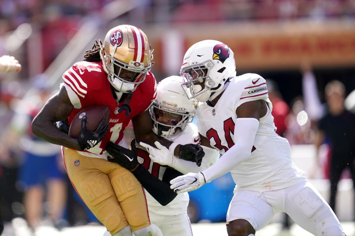 San Francisco 49ers wide receiver Brandon Aiyuk (11) holds onto the ball after making a catch next to Arizona Cardinals cornerback Marco Wilson (20) and safety Jalen Thompson (34) in the second quarter at Levi's Stadium.