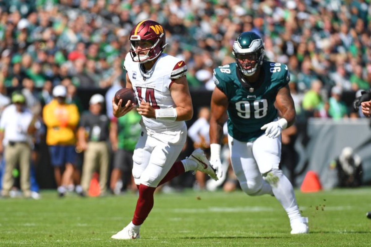 Washington Commanders quarterback Sam Howell (14) runs past Philadelphia Eagles defensive tackle Jalen Carter (98) during the first quarter at Lincoln Financial Field.