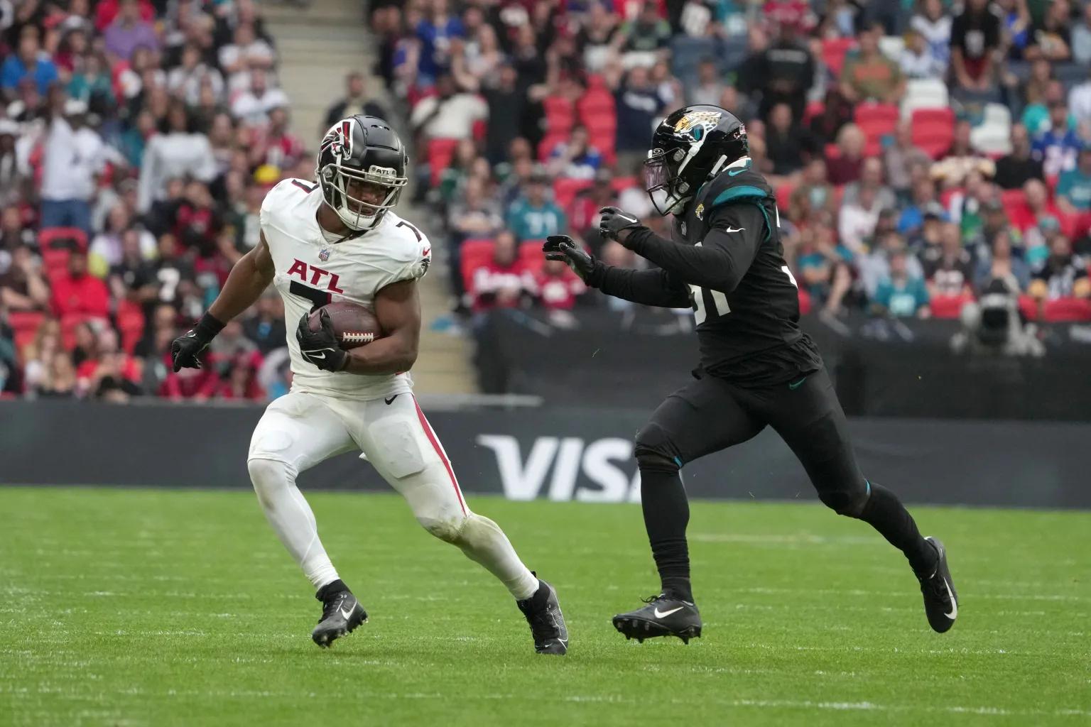 Atlanta Falcons running back Bijan Robinson (7) carries the ball against Jacksonville Jaguars cornerback Darious Williams (31) in the second half during an NFL International Series game