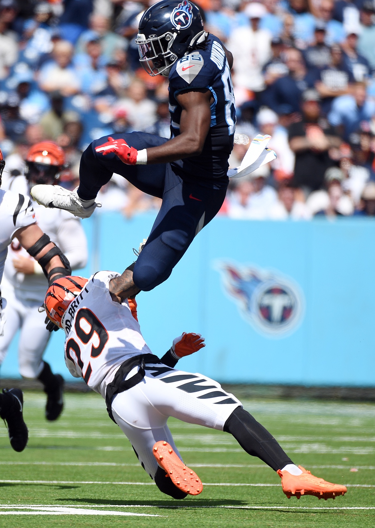 Tennessee Titans tight end Chigoziem Okonkwo (85) attempts to hurdle Cincinnati Bengals cornerback Cam Taylor-Britt (29) after a reception during the first half at Nissan Stadium.
