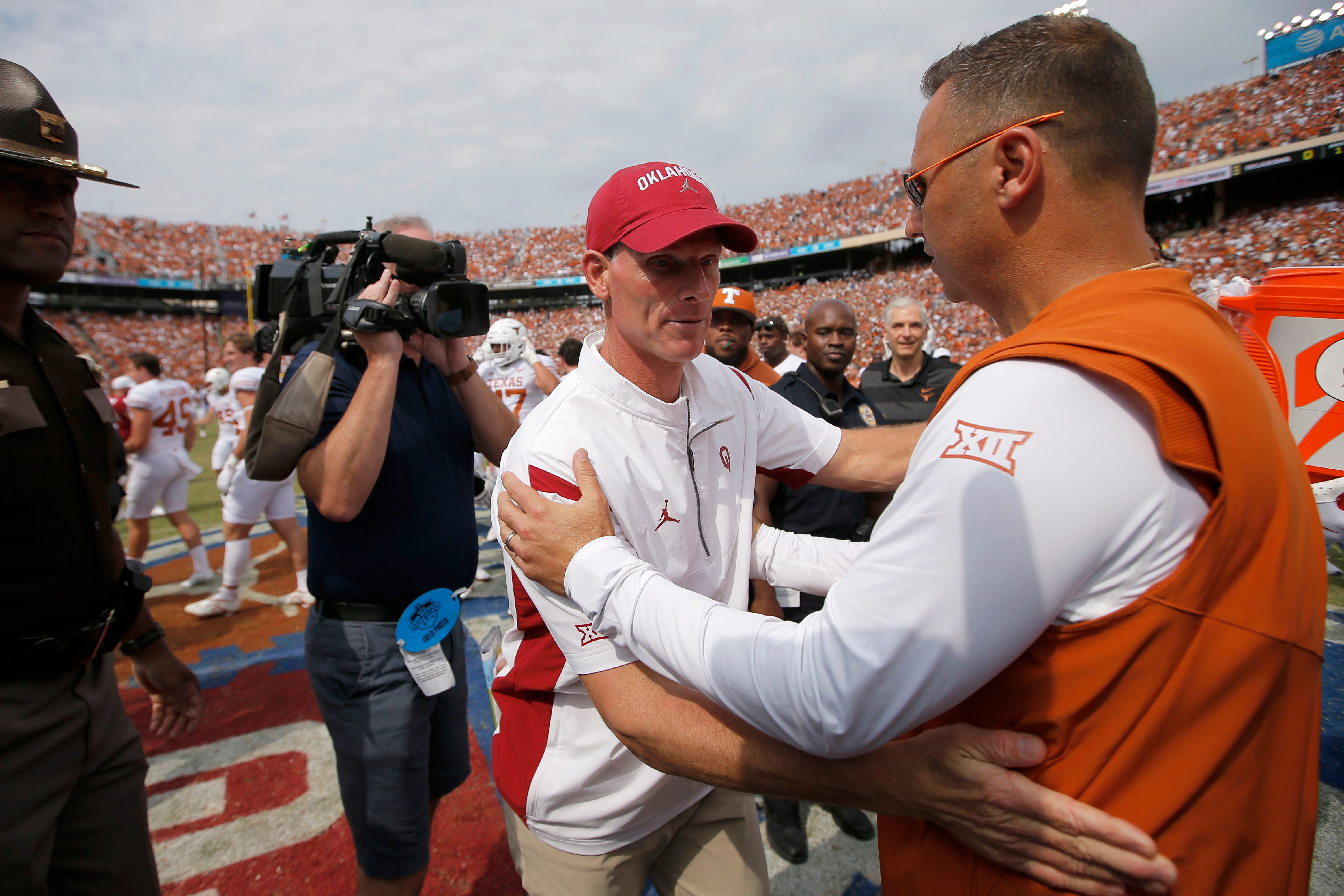 Oklahoma Sooners head coach Brent Venables, left, and Texas Longhorns head coach Steve Sarkisian meet after the Red River Showdown college football game between the University of Oklahoma (OU) and Texas at the Cotton Bowl in Dallas, Saturday, Oct. 8, 2022. Texas won 49-0. 