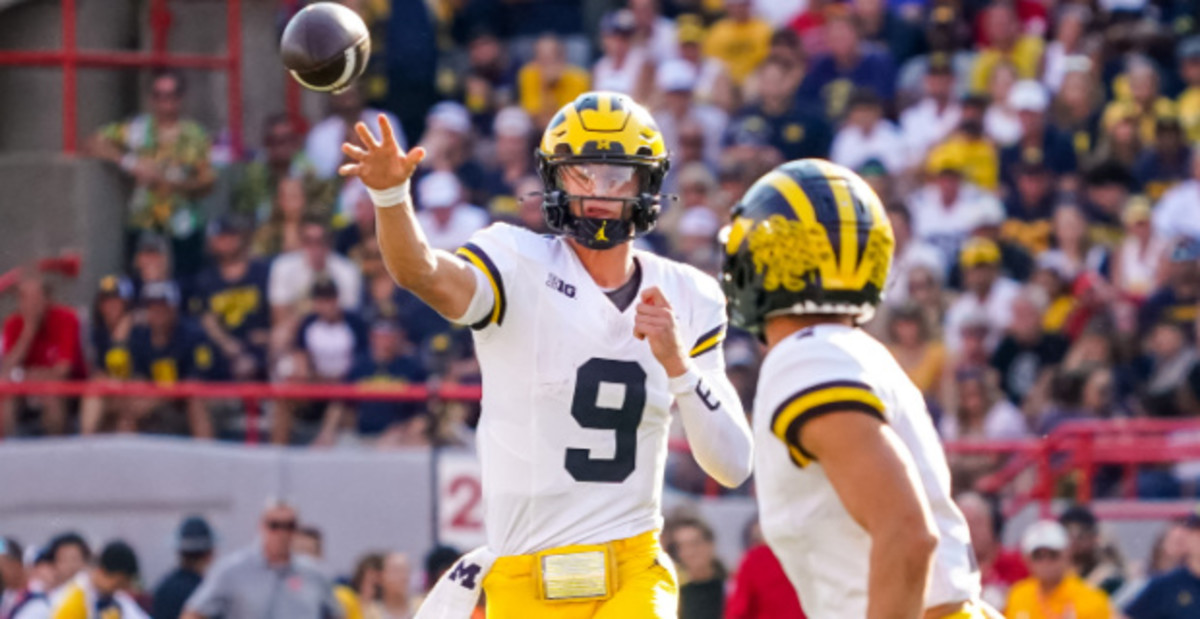 Michigan Wolverines quarterback J.J. McCarthy throws a pass to wide receiver Roman Wilson during a college football game.