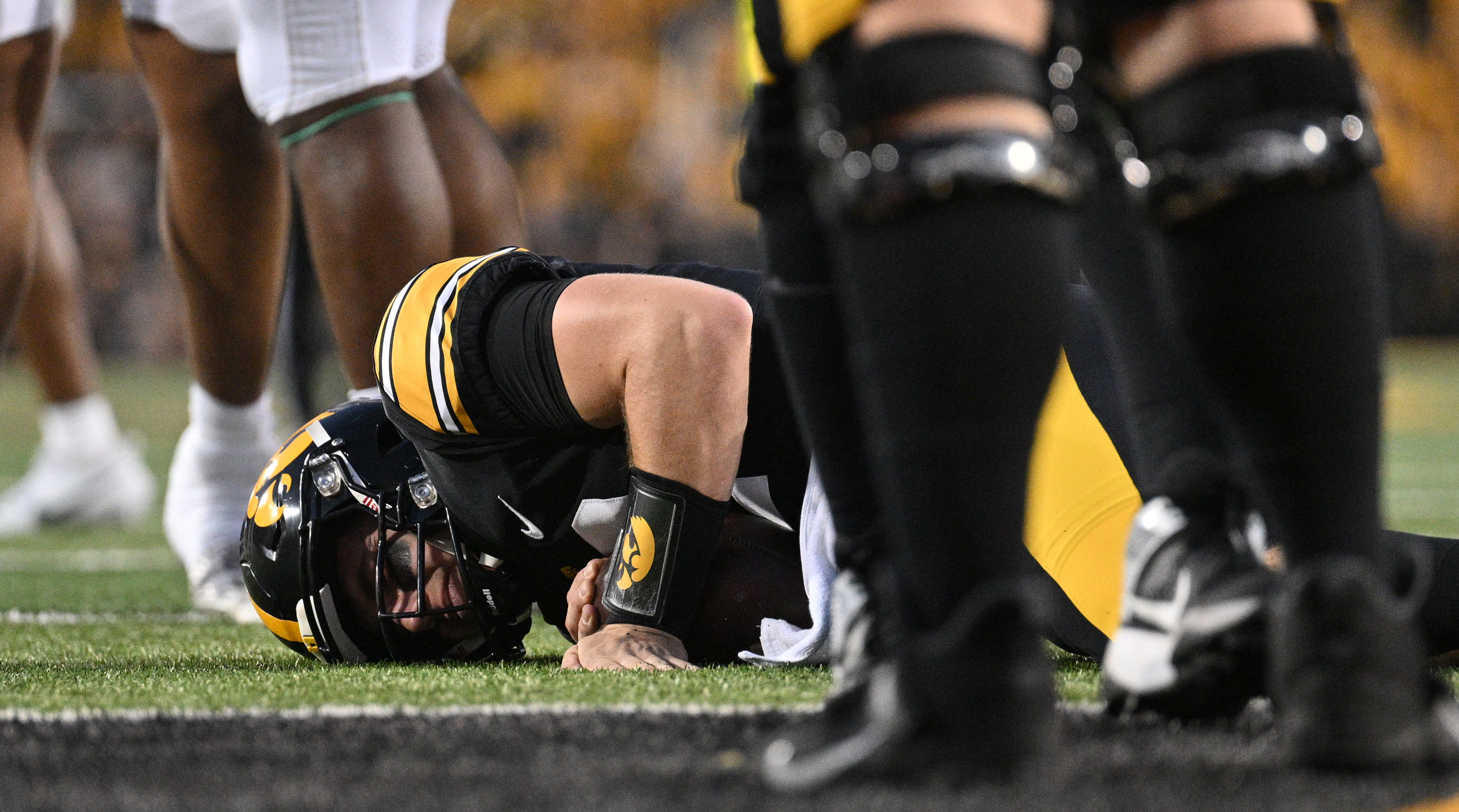 Iowa quarterback Cade McNamara lies on the ground after suffering a leg injury