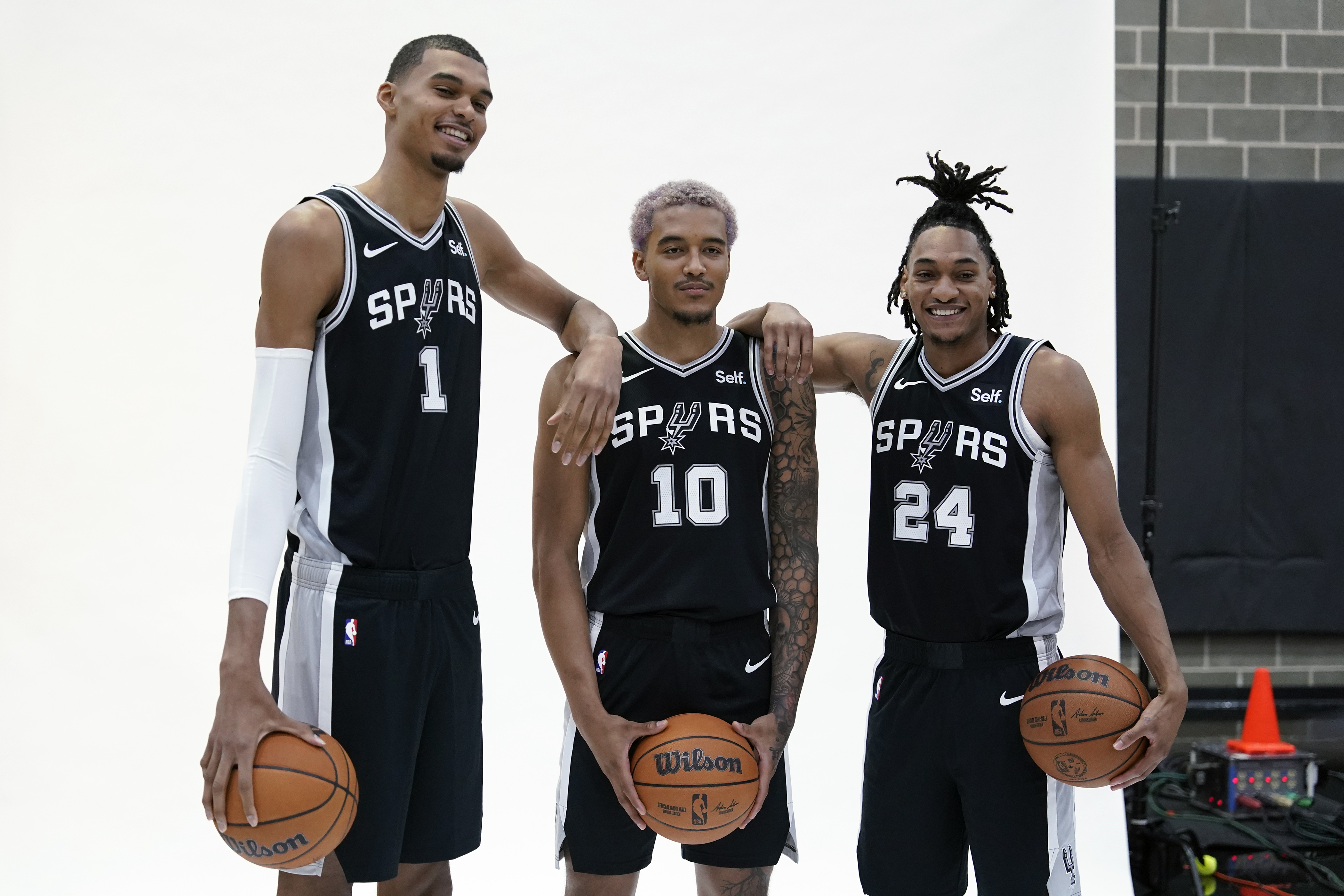 Oct 2, 2023; San Antonio, TX, USA; San Antonio Spurs center Victor Wembanyama (1) poses for photos with forwards guard Devin Vassell (24) and Jeremy Sochan (10) during media day in San Antonio.