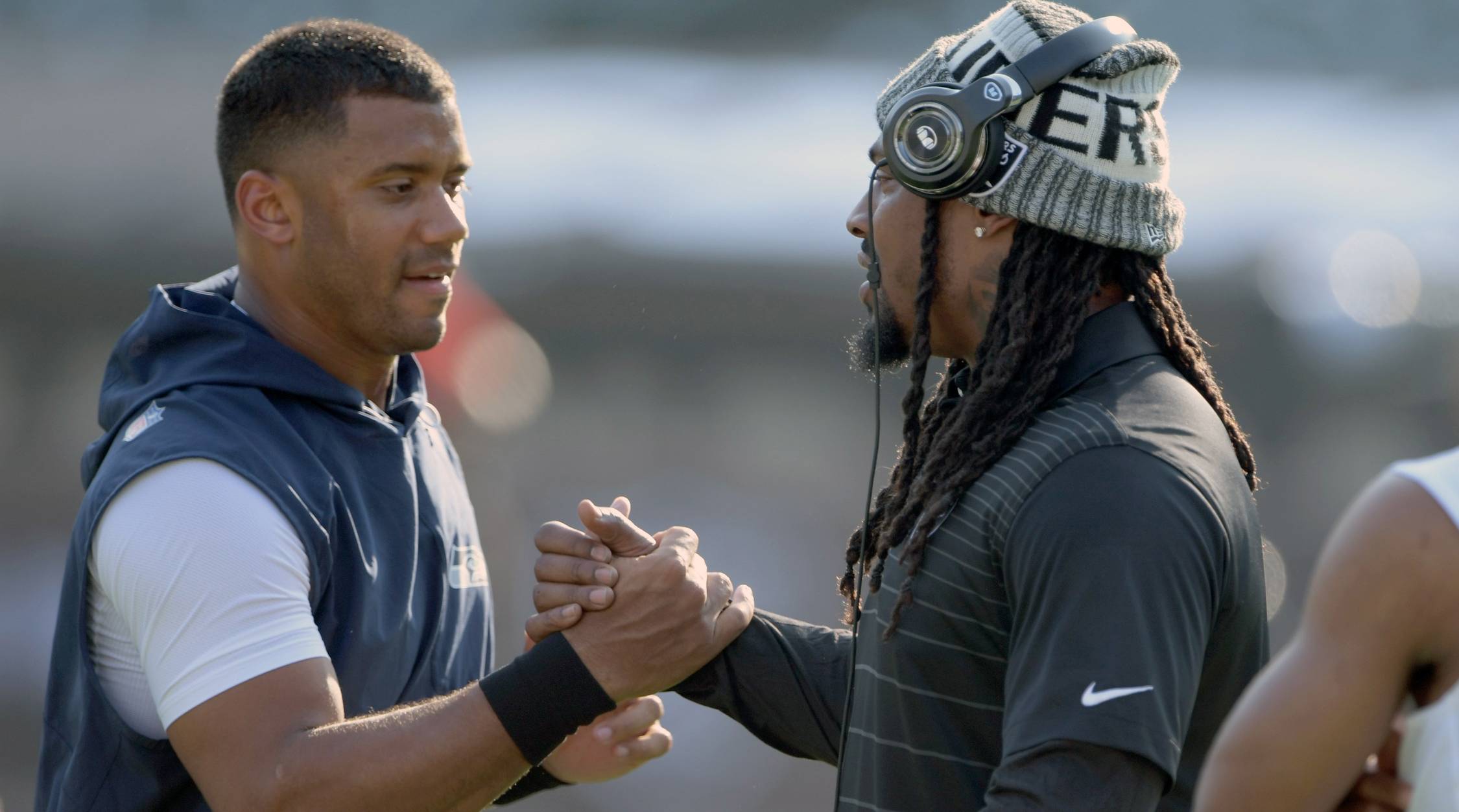 Seahawks quarterback Russell Wilson and Raiders running back Marshawn Lynch embrace before a game.