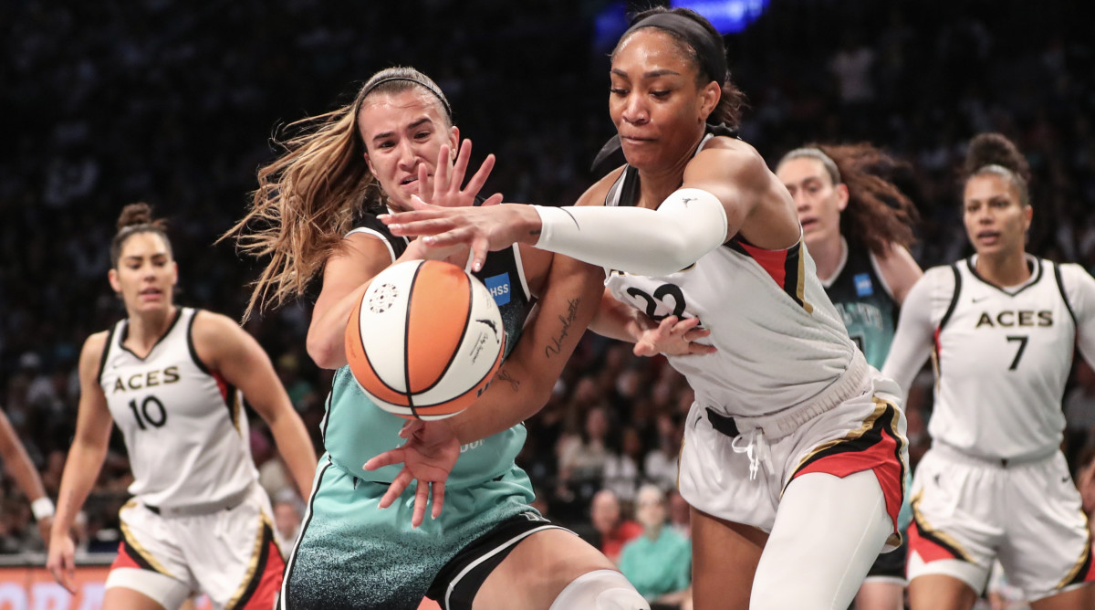 New York Liberty guard Sabrina Ionescu  and Las Vegas Aces forward A'ja Wilson fight for a loose ball.