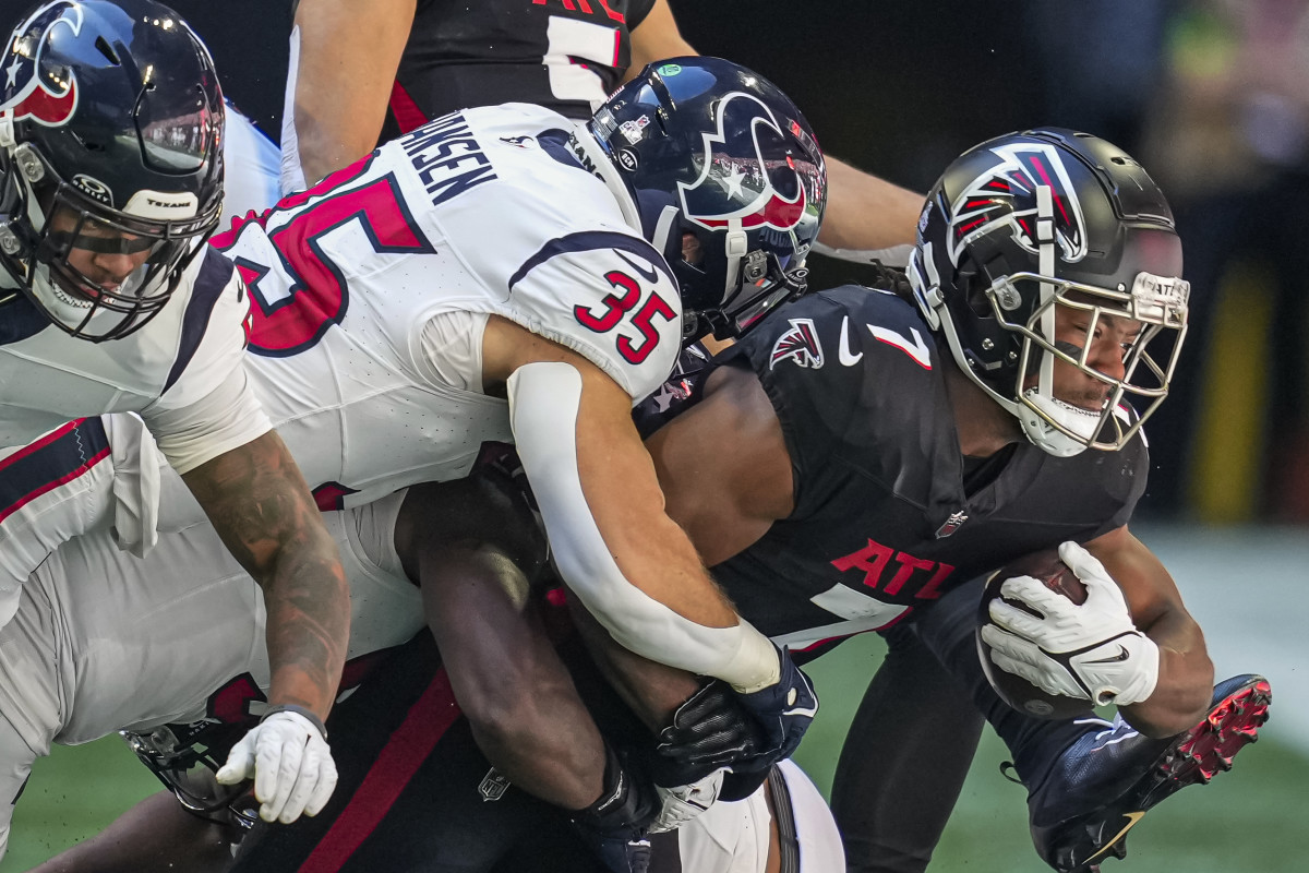 Falcons running back Bijan Robinson (7) is tackled by Houston Texans linebacker Jake Hansen (35) during the first half at Mercedes-Benz Stadium.