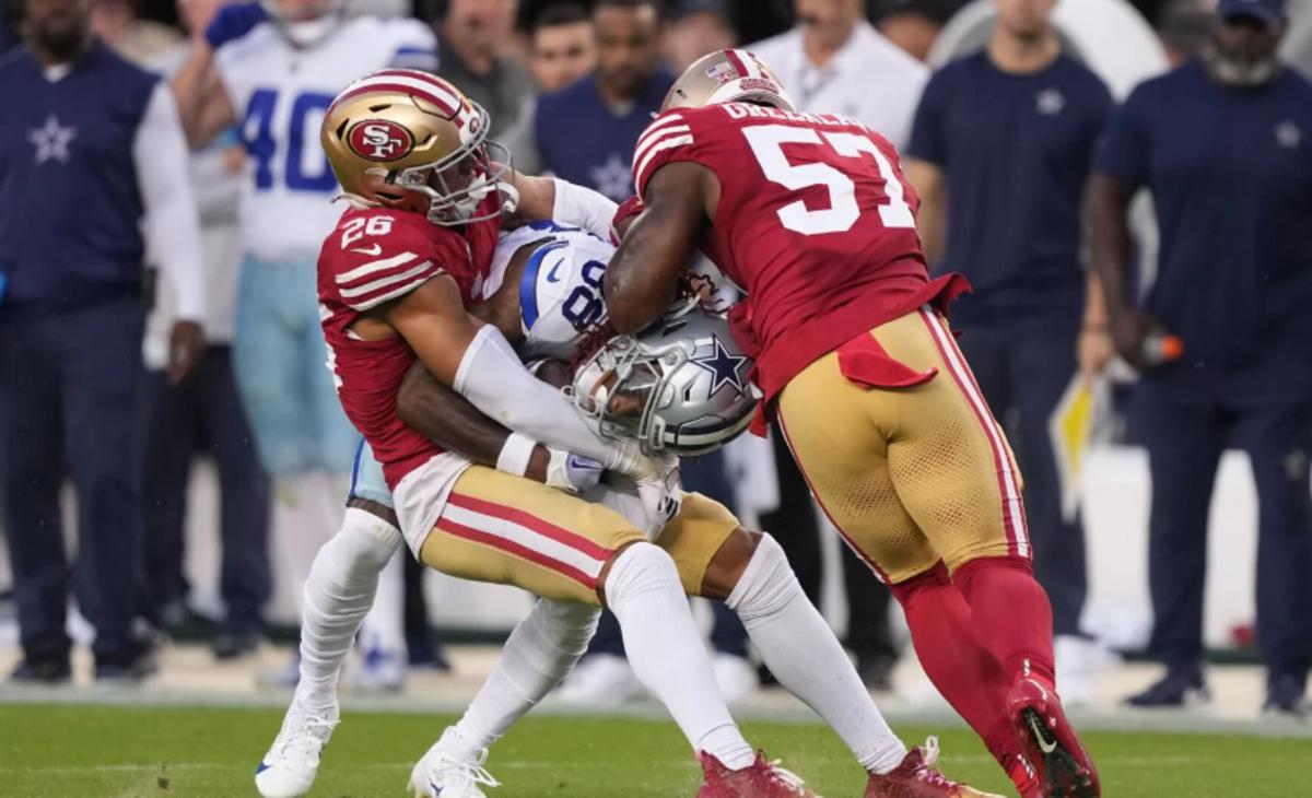 Dallas Cowboys wide receiver CeeDee Lamb (center) is tackled by San Francisco 49ers cornerback Isaiah Oliver (26) and linebacker Dre Greenlaw (57) during the second quarter at Levi's Stadium.