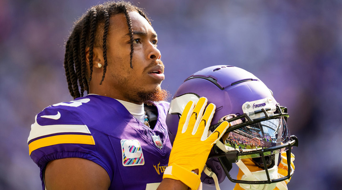 Justin Jefferson holding his helmet in his yellow gloves