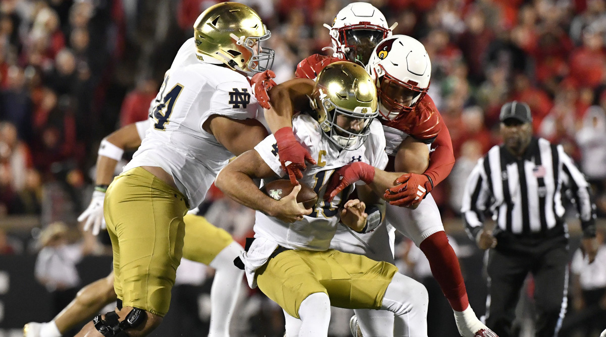 Louisville defensive lineman Ashton Gillotte sacks Notre Dame quarterback Sam Hartman.